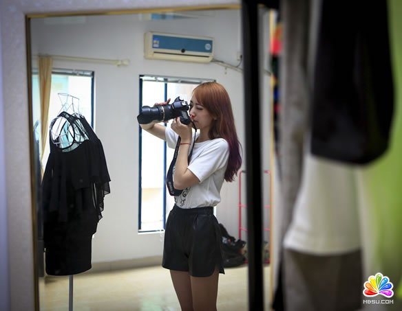 淘寶店主汪杭萍正在給衣服拍攝細節圖